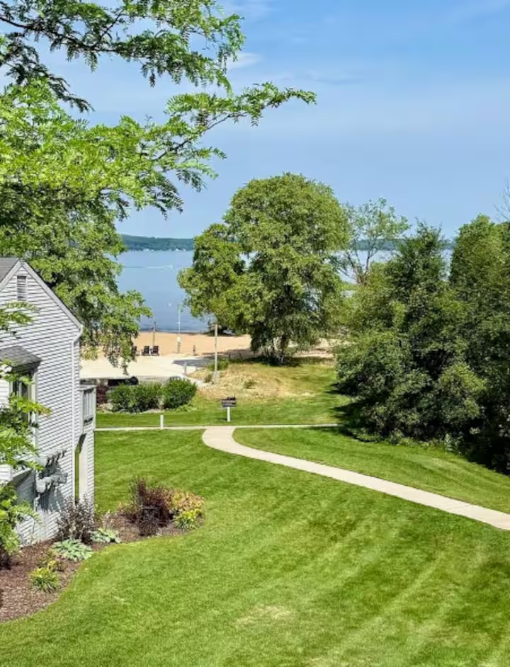 Green resort grounds leading toward East Grand Traverse Bay